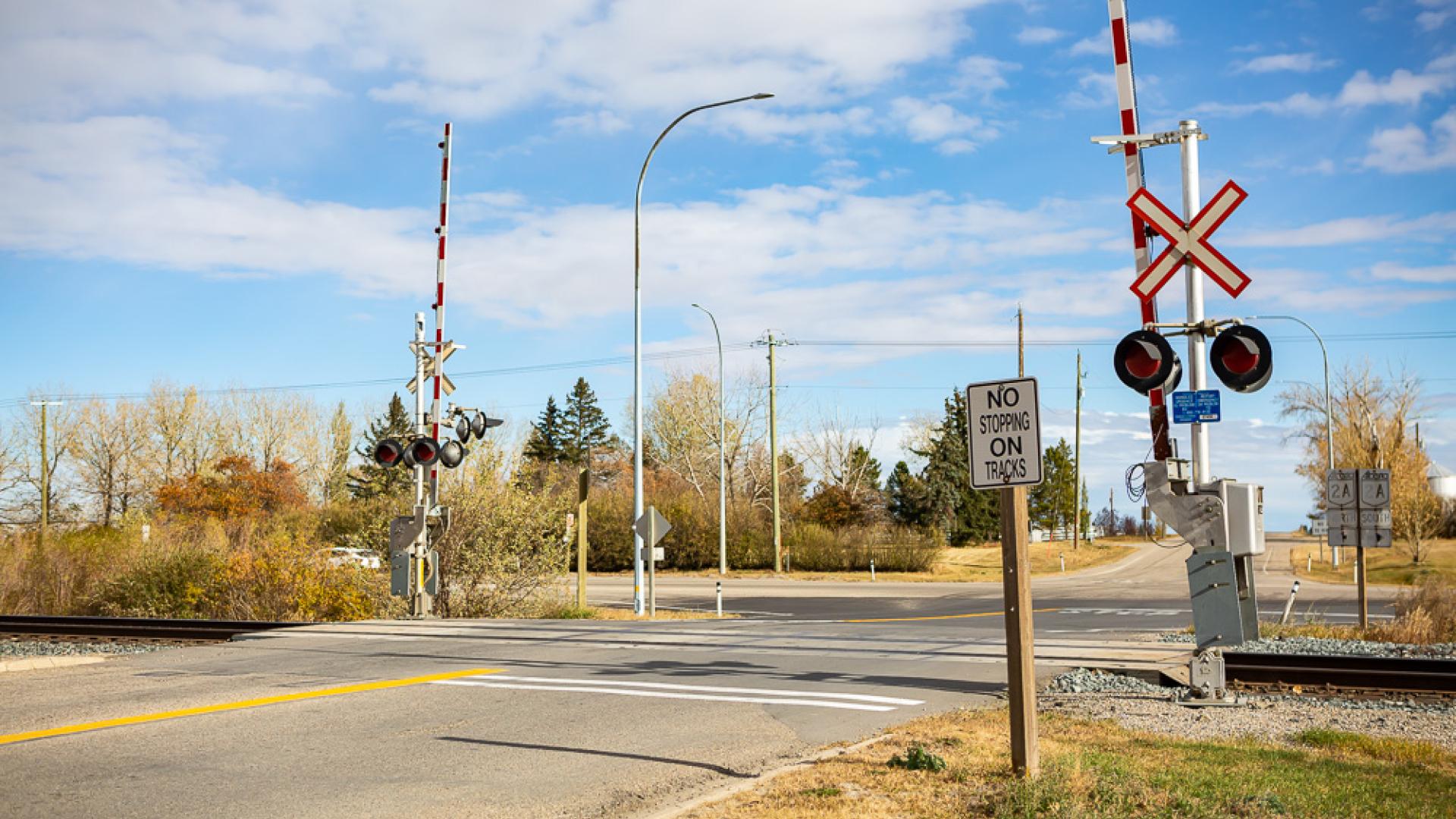 Railway crossing with red and white arms on a sunny summer day