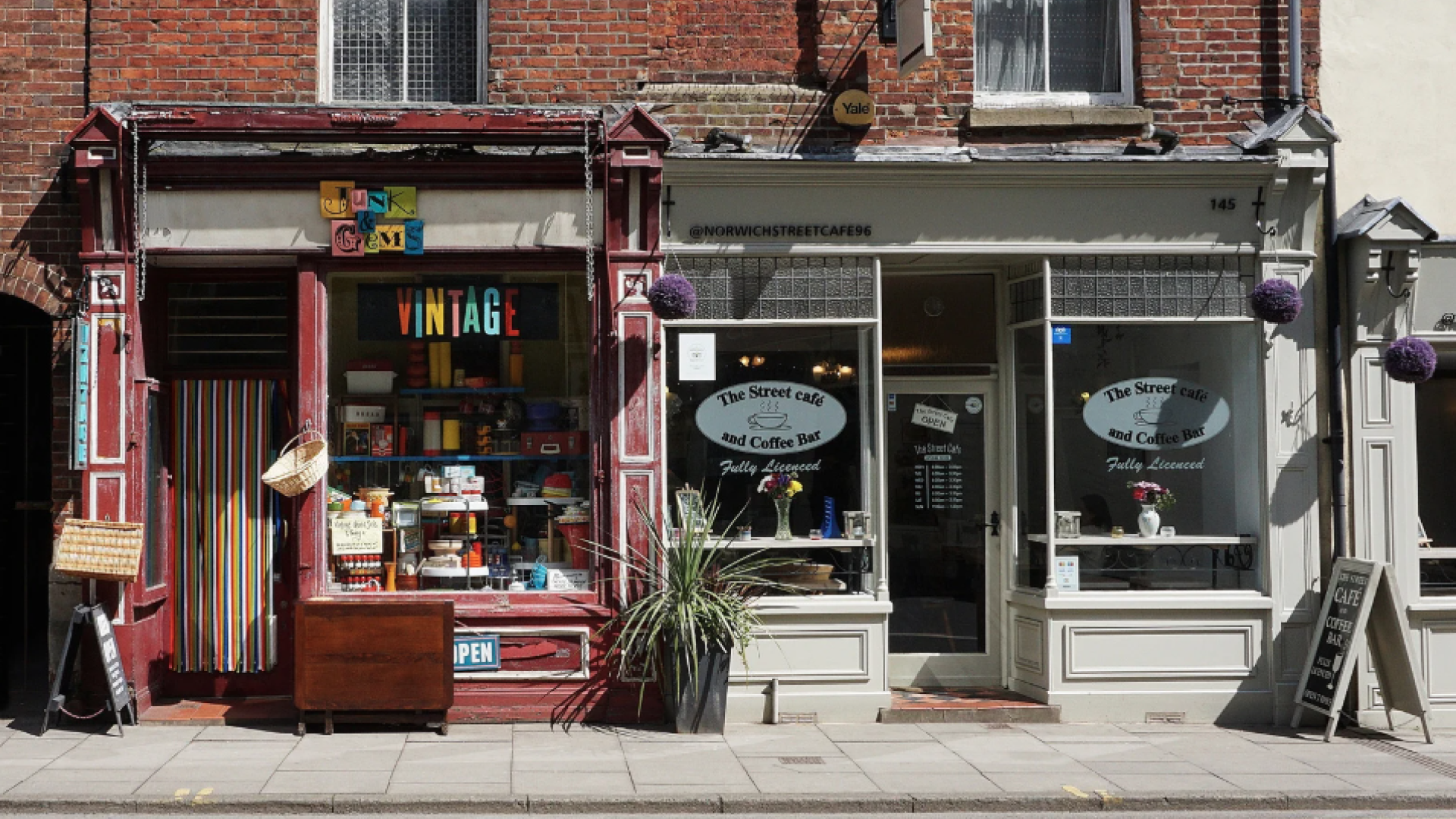 Two small storefront businesses—a vintage shop and a café—sit side by side on a street, representing local retail and service enterprises.